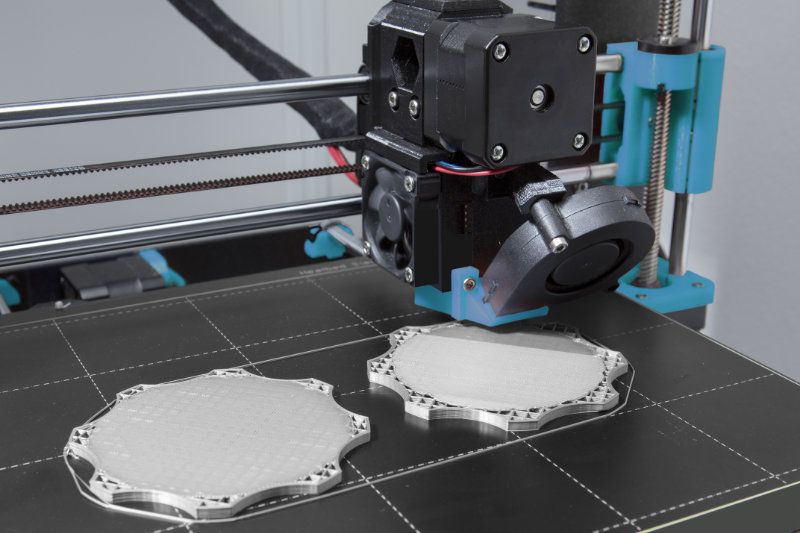 3D-Drucker bei der Fertigung von zwei Bauteilen