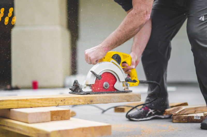 Bau und Handwerk: Handwerker beim Zersägen von Latten